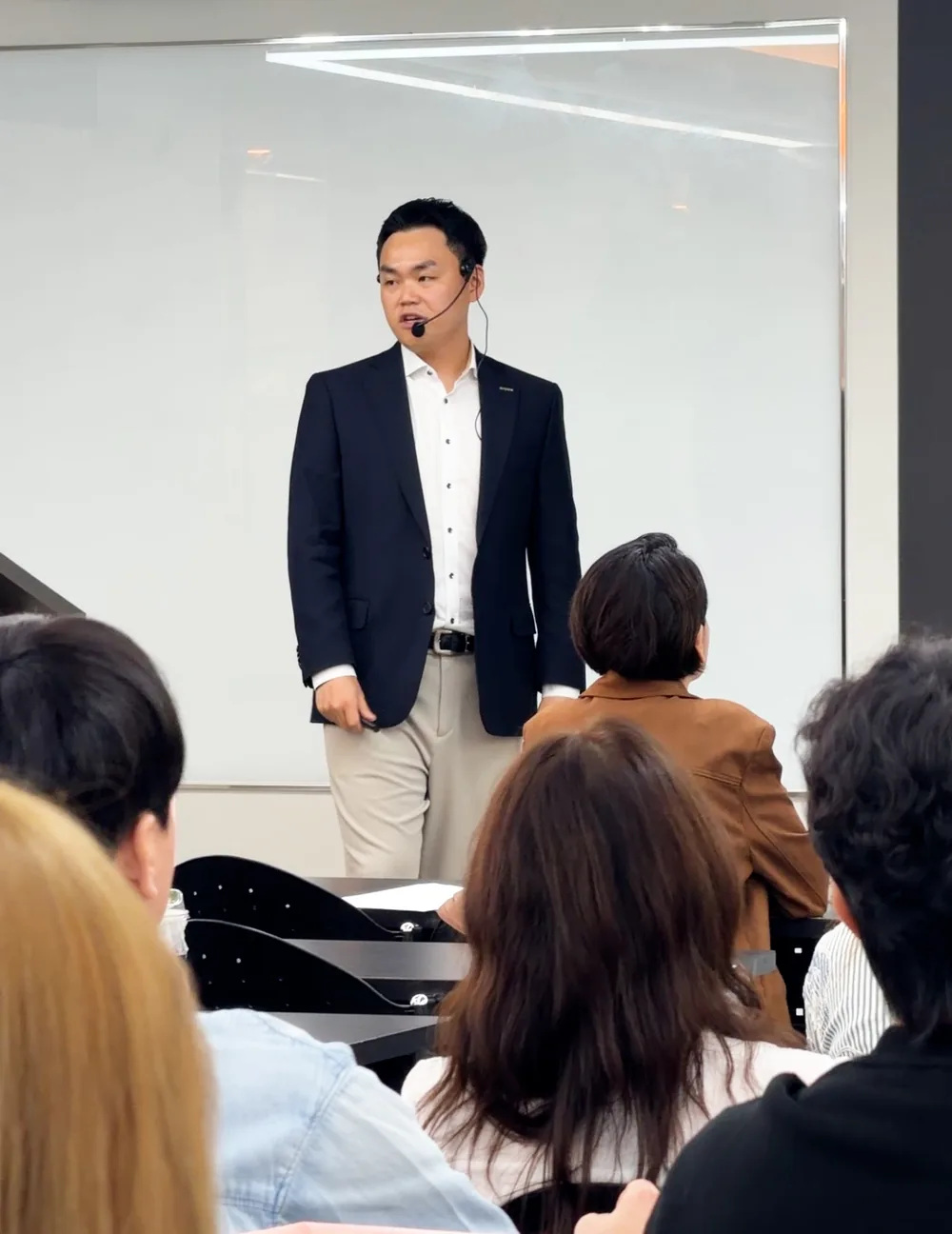 화이트보드 앞에서 참석자들을 바라보며 말하는 유준식